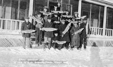 Men in winter coats holding Great Northern pike, Pequot Lakes Minnesota, 1915