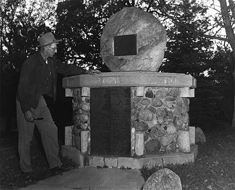 Evan Engebretson standing by Pioneer memorial in Highland Prairie Lutheran Church park, Peterson Minnesota, 1955