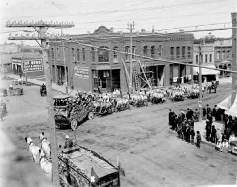 Parade for unidentified circus turns off Front Street (Center Ave.) onto 4th Street N. in downtown Moorhead Minnesota, 1903
