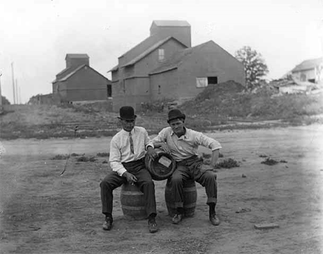 Two men seated on beer kegs, Underwood Minnesota, 1910