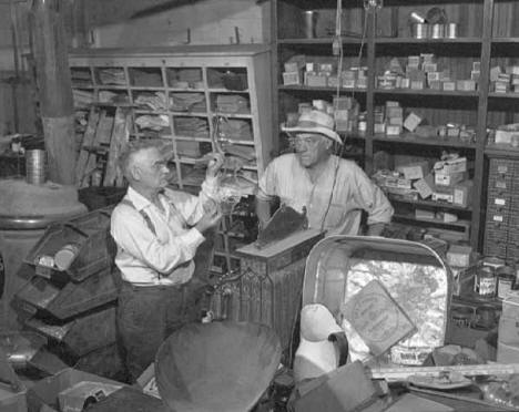 Owner Robert E. Gadola with unidentified man in the Gadola Hardware Store in Ogilvie Minnesota
