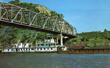 Mississippi River, Eisenhower Bridge, and tugboat pulling barges, Red Wing Minnesota, 1960s